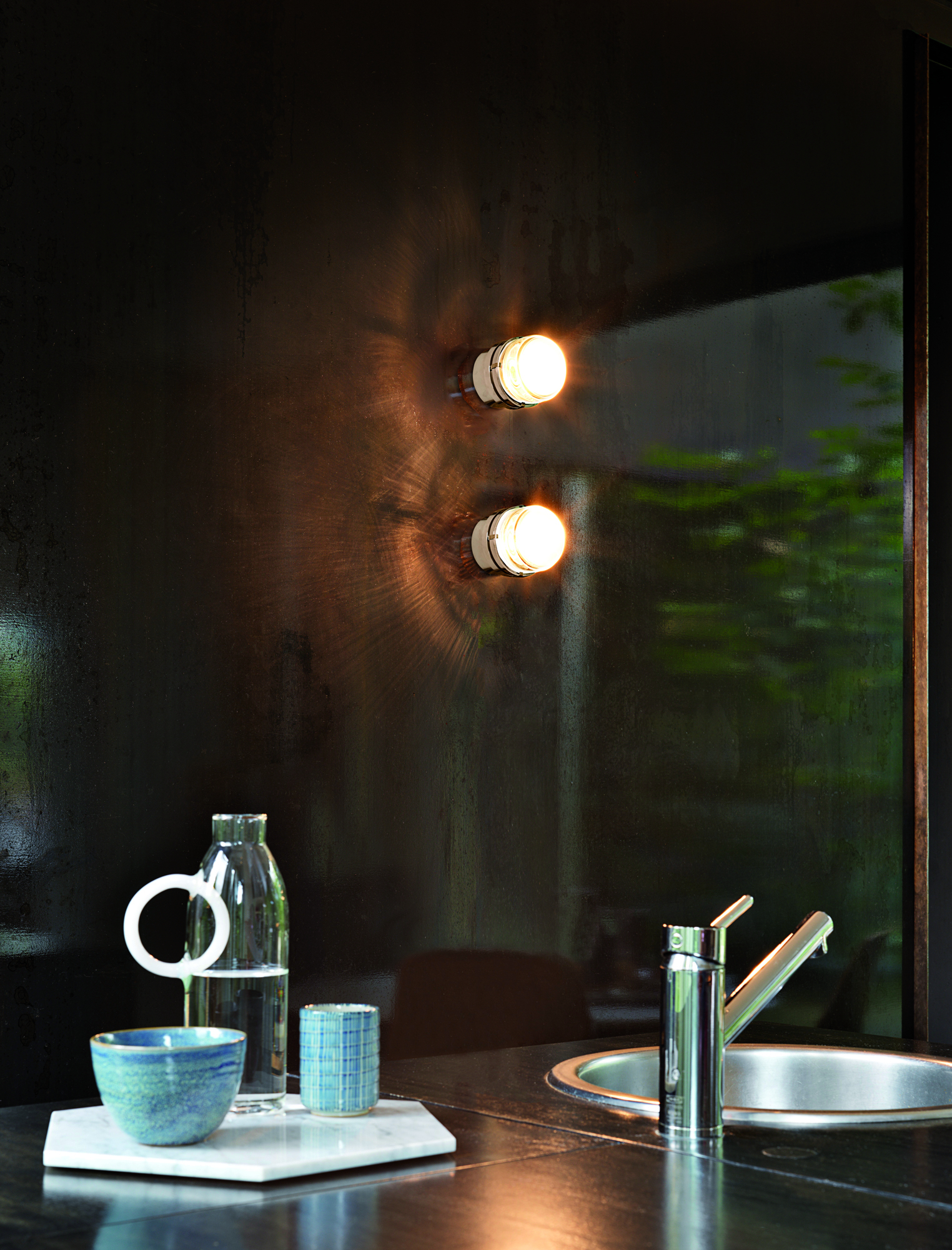 Fresnel Wandleuchte für Aussenbereich: Zwei weiss-transparente Oluce Lampen an dunkler Wand.