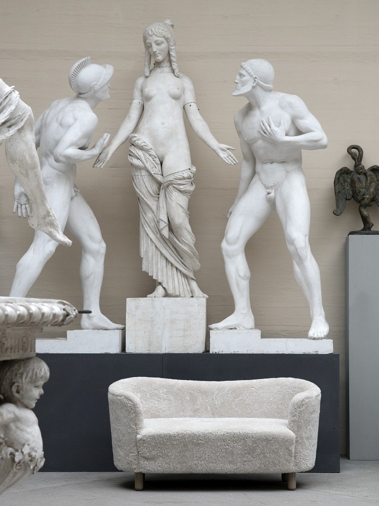 Beiges Audo Mingle Sofa 2-Sitzer vor Statuen. Modernes Sofa für Wohnzimmer und stilvolles Interieur.