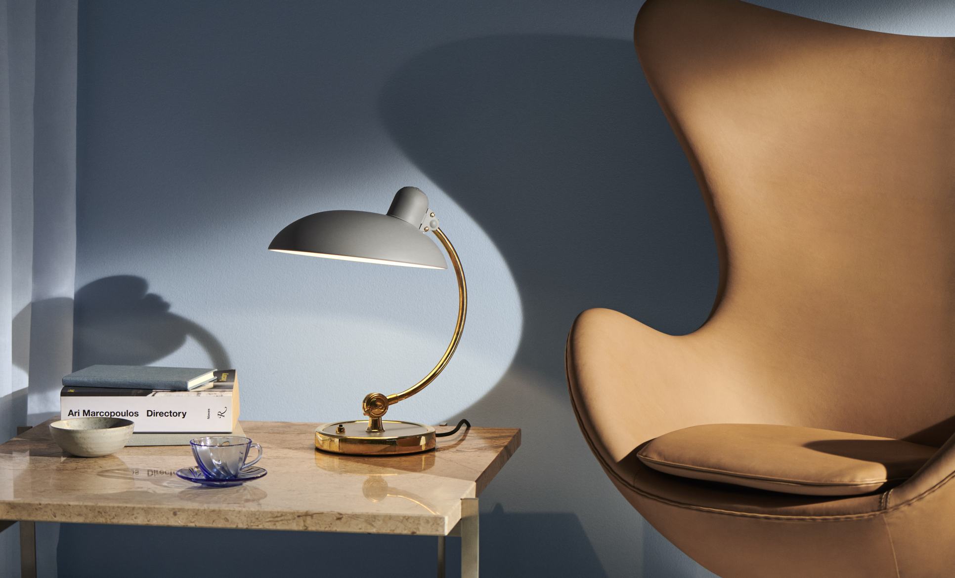 Graue Kaiser idell Tischleuchte mit goldenem Gestell, modernes Design für Schreibtisch und Nachttisch.