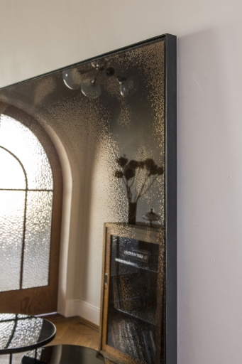 Ethnicraft Wandspiegel im Used-Look mit bronzefarbenem Rahmen, reflektiert stilvolles Interieur und natürliches Licht.