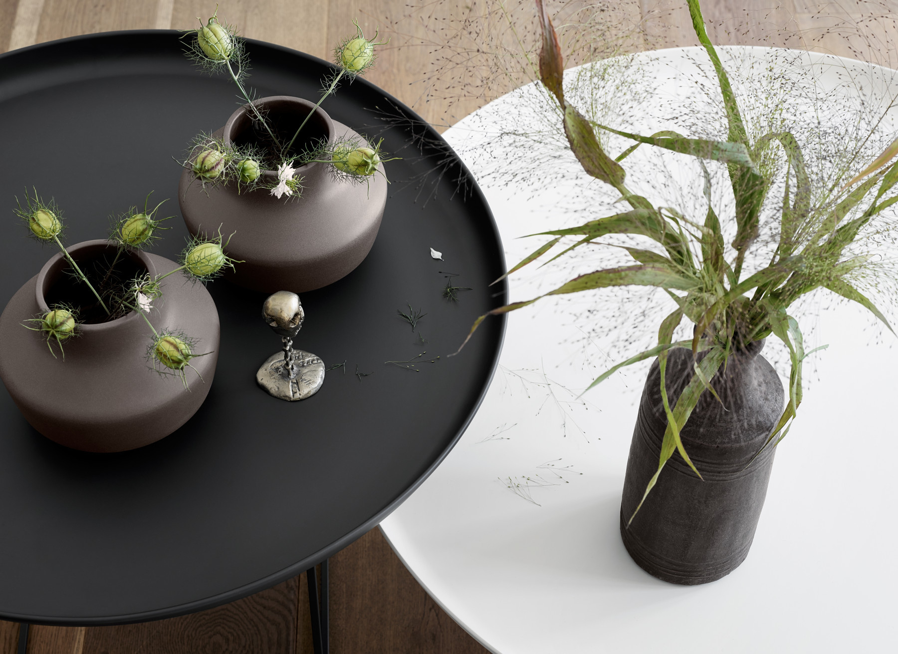 Duke Coffee Table Medium Couchtisch Norr11 Earth black mit Vasen und Dekoration auf schwarzer und weißer Tischplatte.