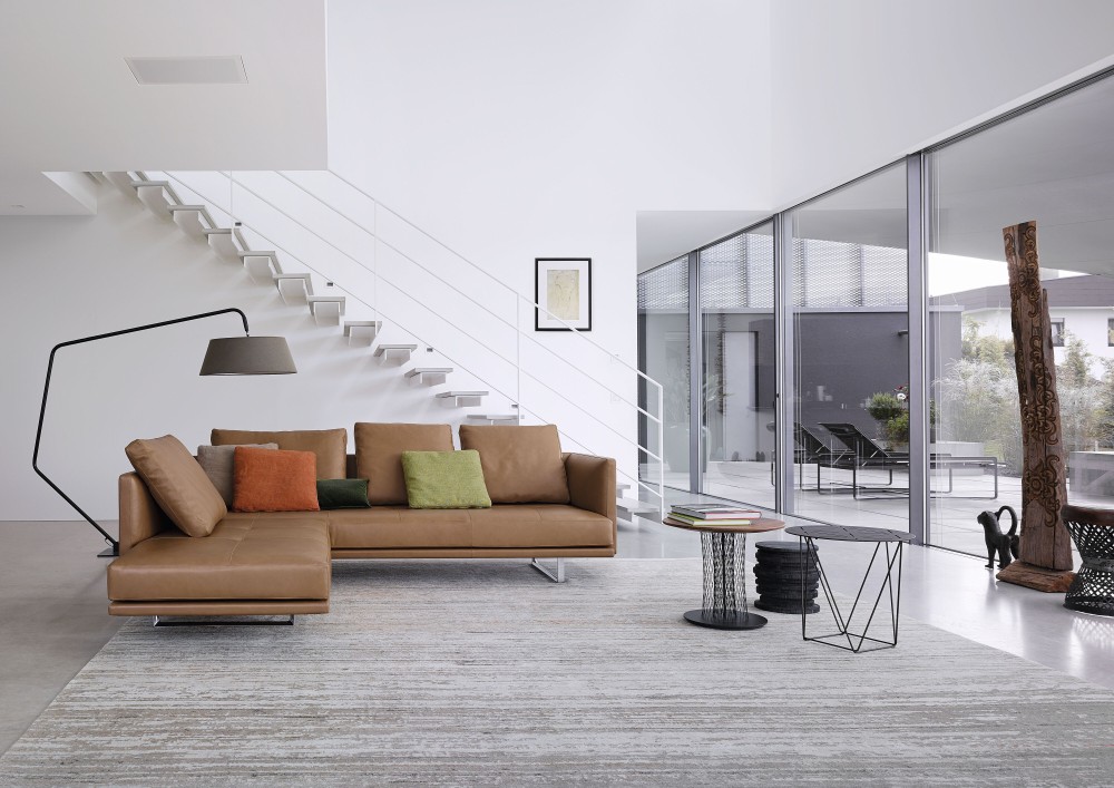 Moderner Wohnraum mit Joco Beistelltisch von Walter Knoll, Couch, Teppich und minimalistischer Einrichtung.