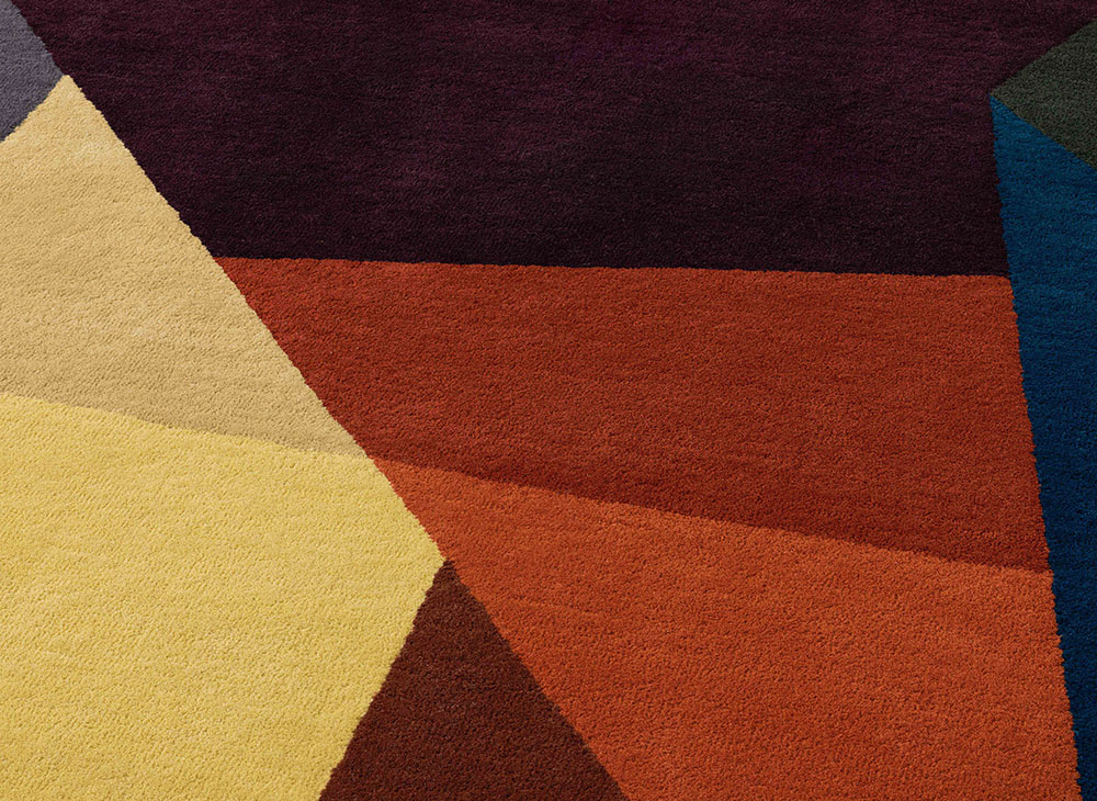 Nahaufnahme des Loko Rug Teppichs mit geometrischen Formen in Gelb, Braun, Burgunder und Blau.