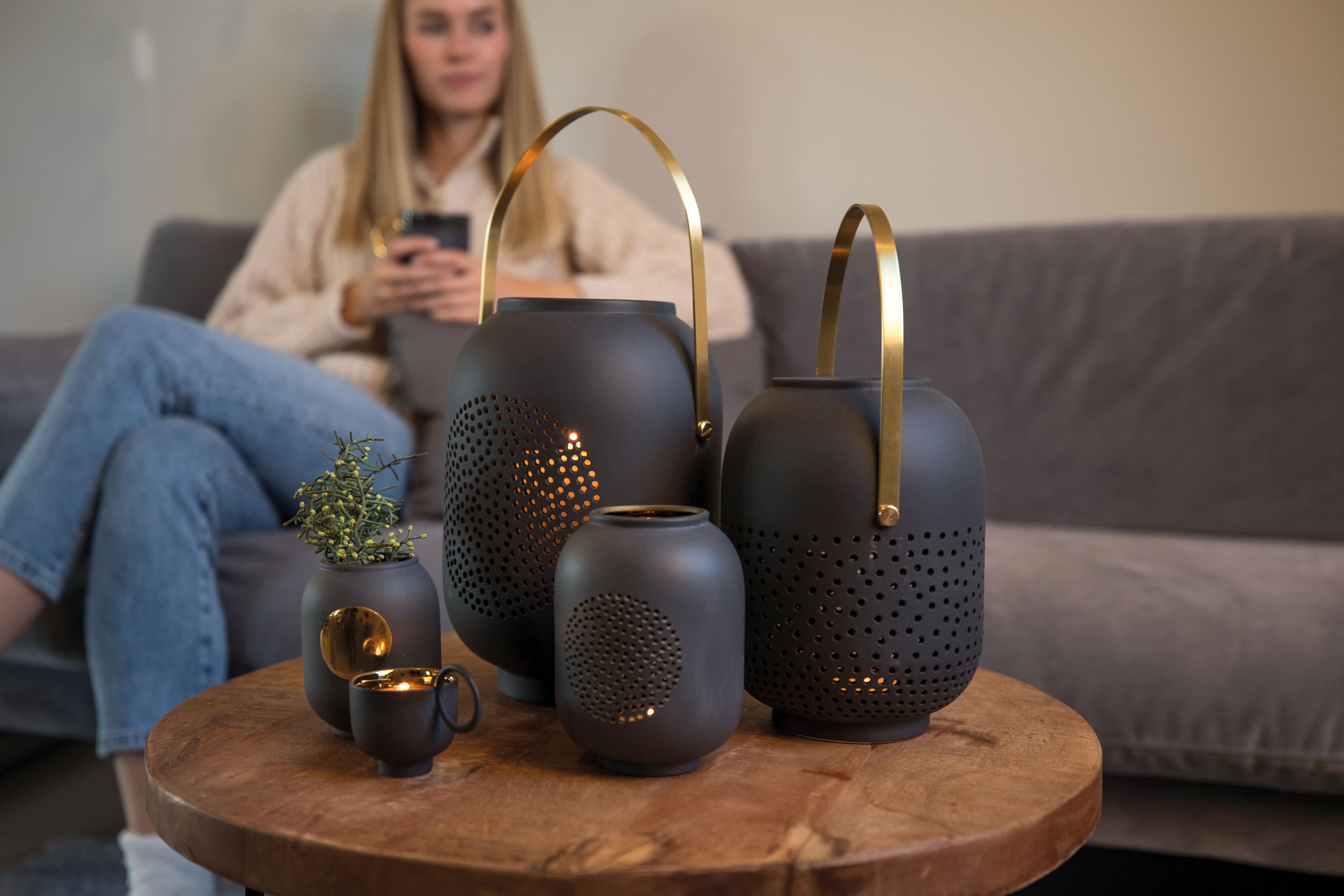 Dekorative Zuhausesein Laterne Mond Räder EINZELSTÜCK aus Keramik in Anthrazit mit goldenen Akzenten auf Holztisch.