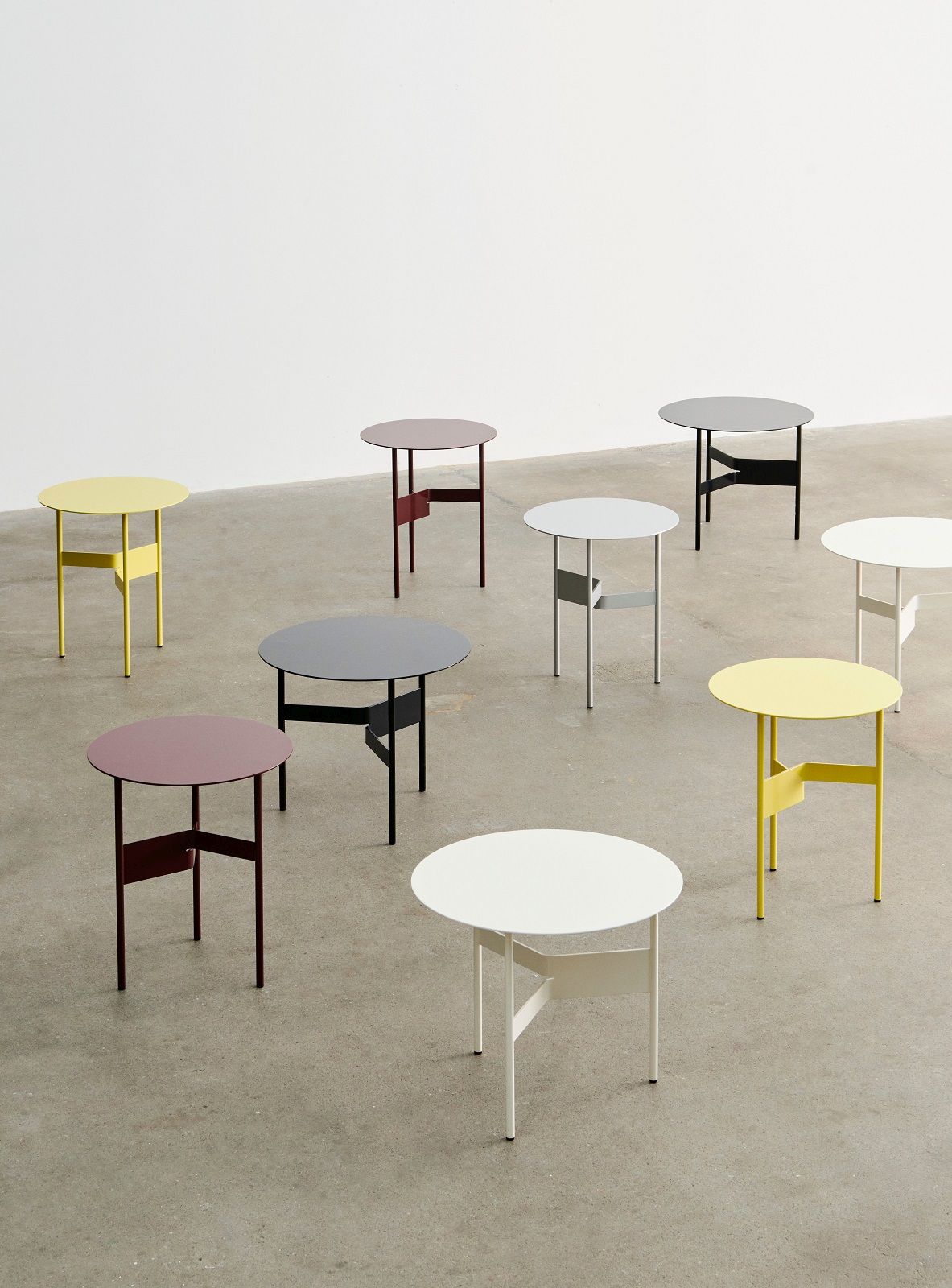 Mehrere farbige Hay Shim Table Couchtische mit runden Tischplatten und minimalistischem Design.