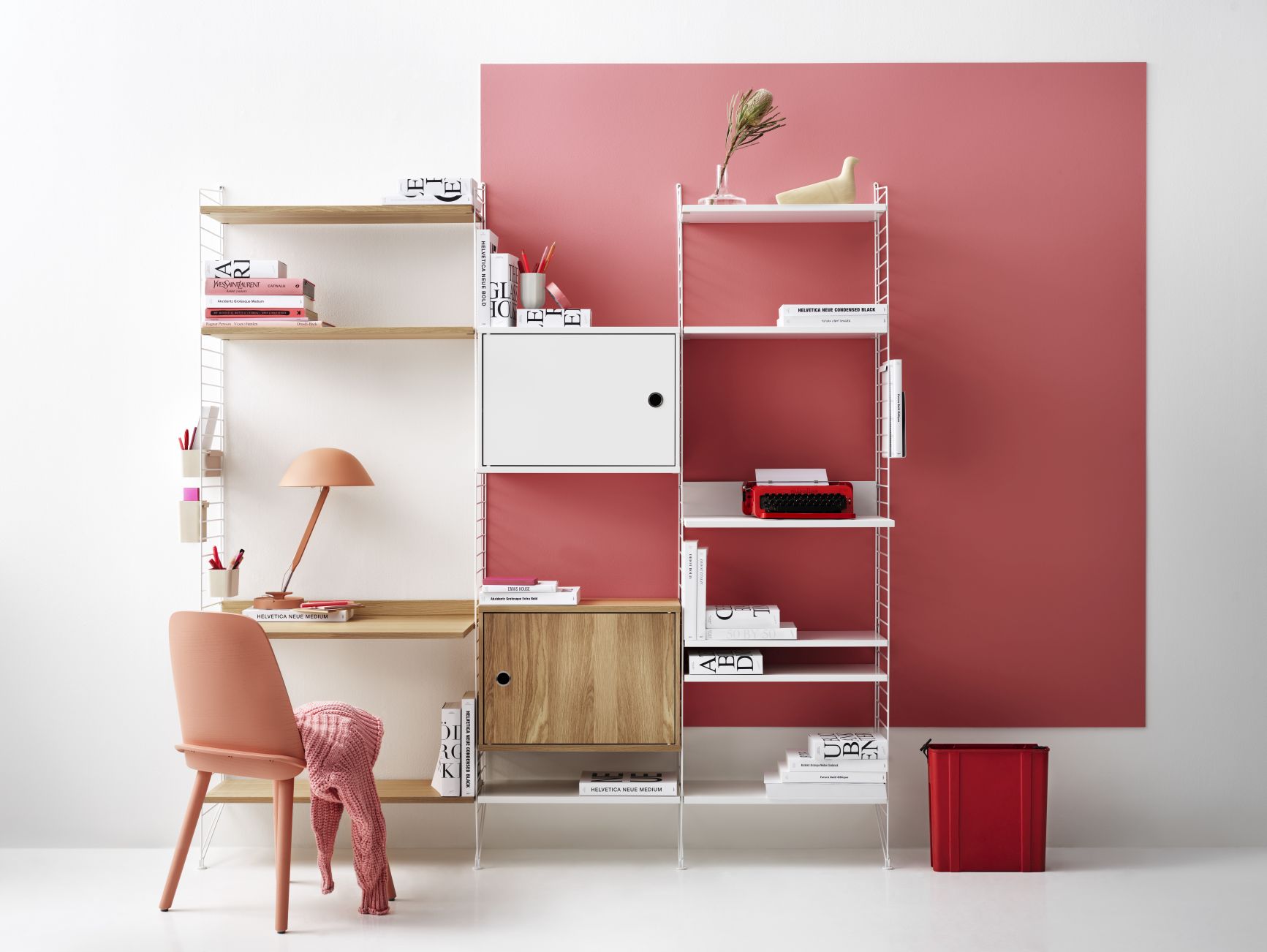 Modernes String Regalsystem in Weiß und Holz mit Schreibtisch und rosa Akzenten.