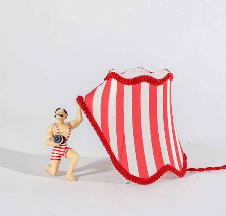 Circus AbatJour Leuchte: Zirkuslampe mit rot-weiß gestreiftem Lampenschirm und Gewichtheber-Figur.