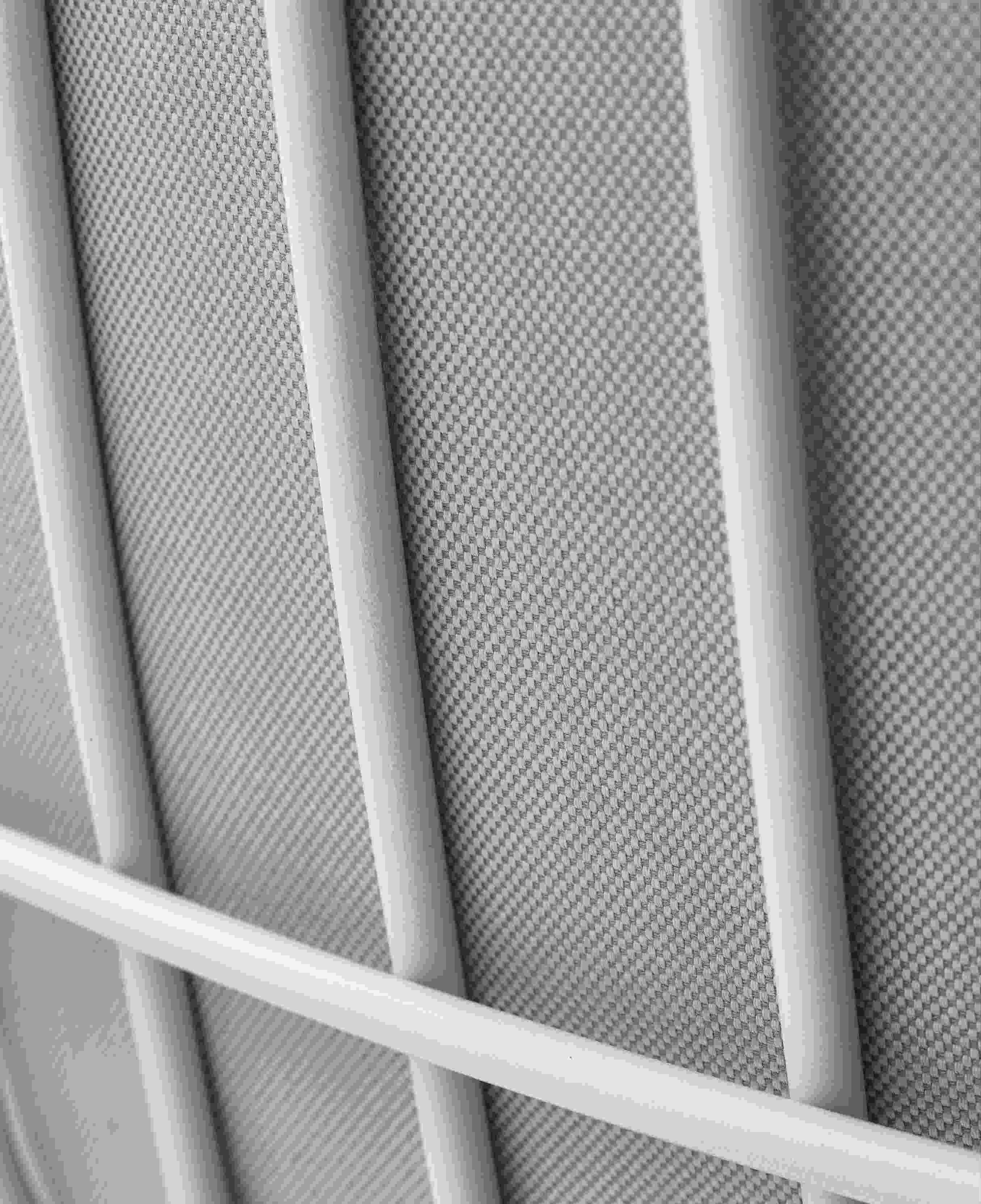 Detailaufnahme des Leyasol Lounge Chair von Freifrau Manufaktur: Weißes Metallgestell und grauer Outdoor-Stoff.