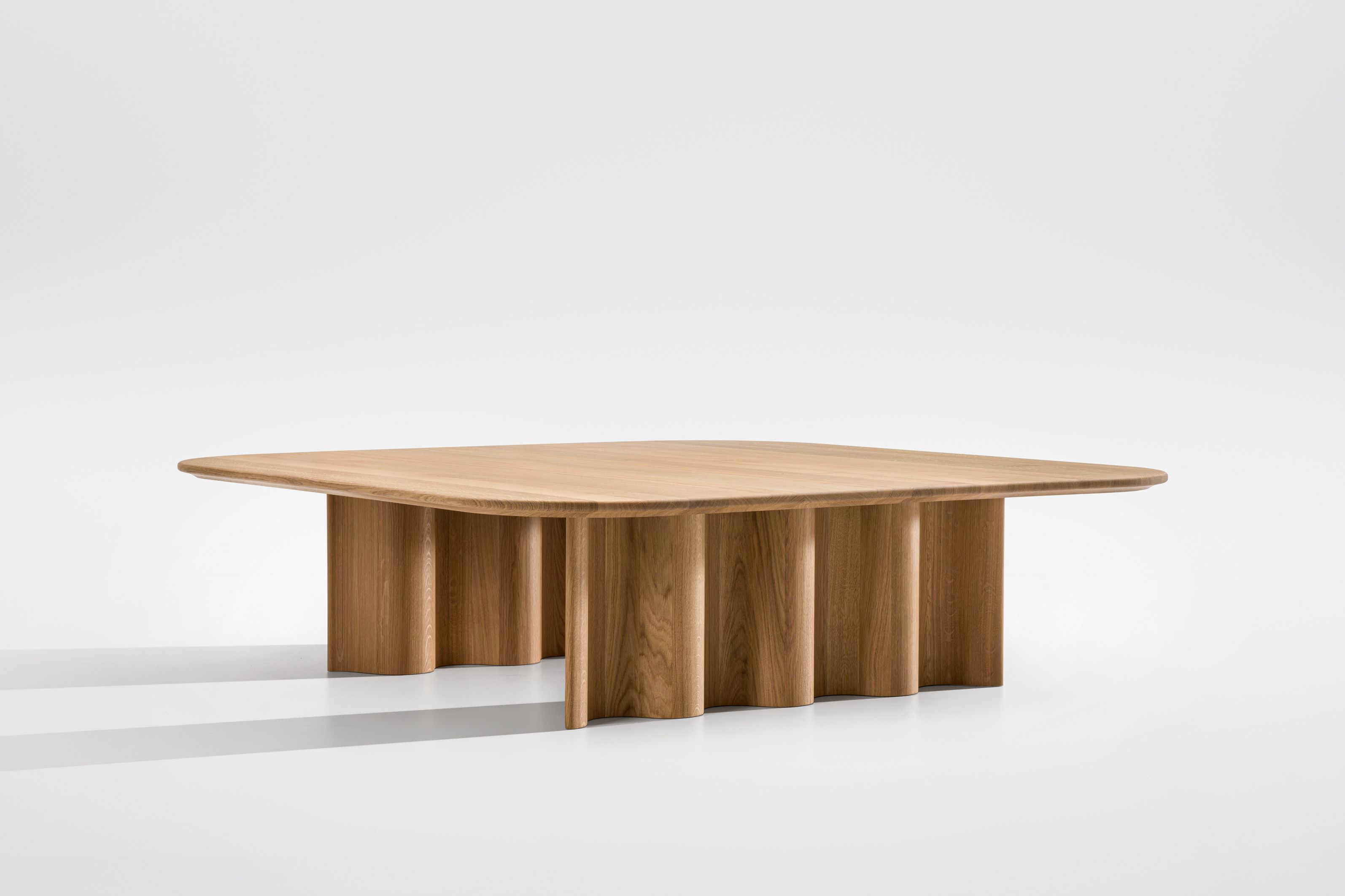 Rechteckiger Curtain Couchtisch aus massivem Eichenholz mit abgerundeten Ecken und wellenförmigem Sockel.