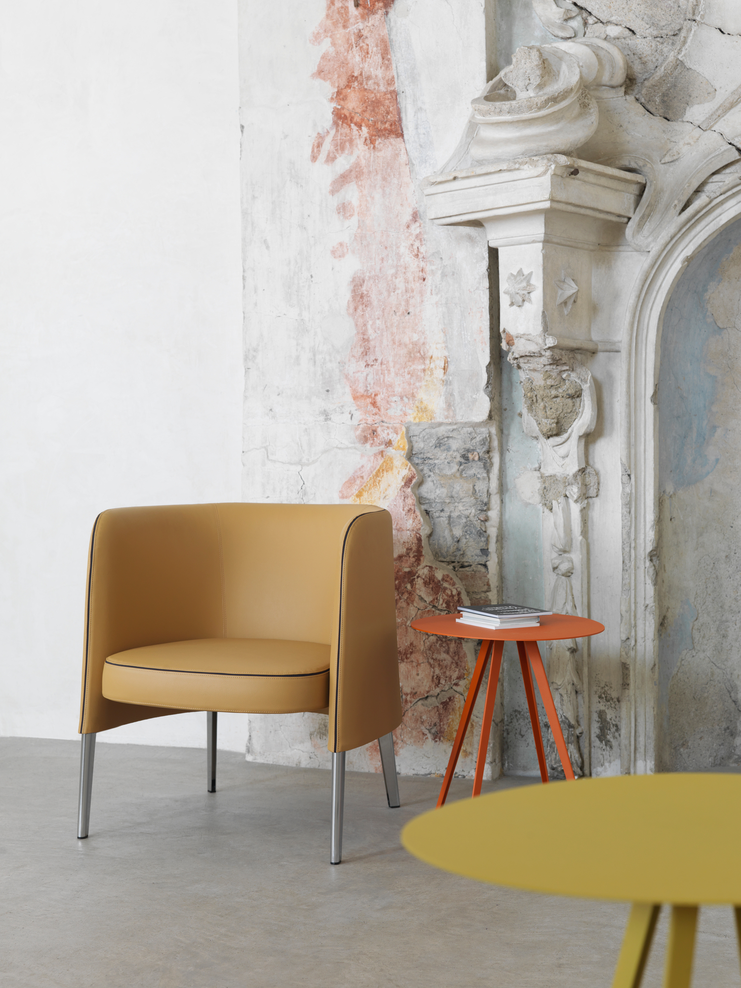 Oranger Agorà Beistelltisch von Segis, runder Tisch mit Buch, modernes Designmöbel für Wohnzimmer und Büro.