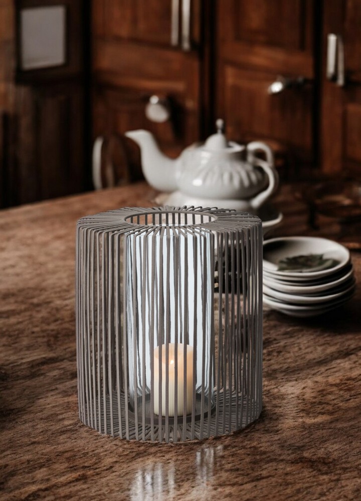 Oslo Windlicht von Philippi, hoch, aus Metall mit Glaszylinder und brennender Kerze.