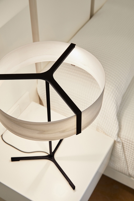 Thesis Tischleuchte von LZF Lamps mit rundem Lampenschirm und schwarzem Gestell auf Nachttisch.