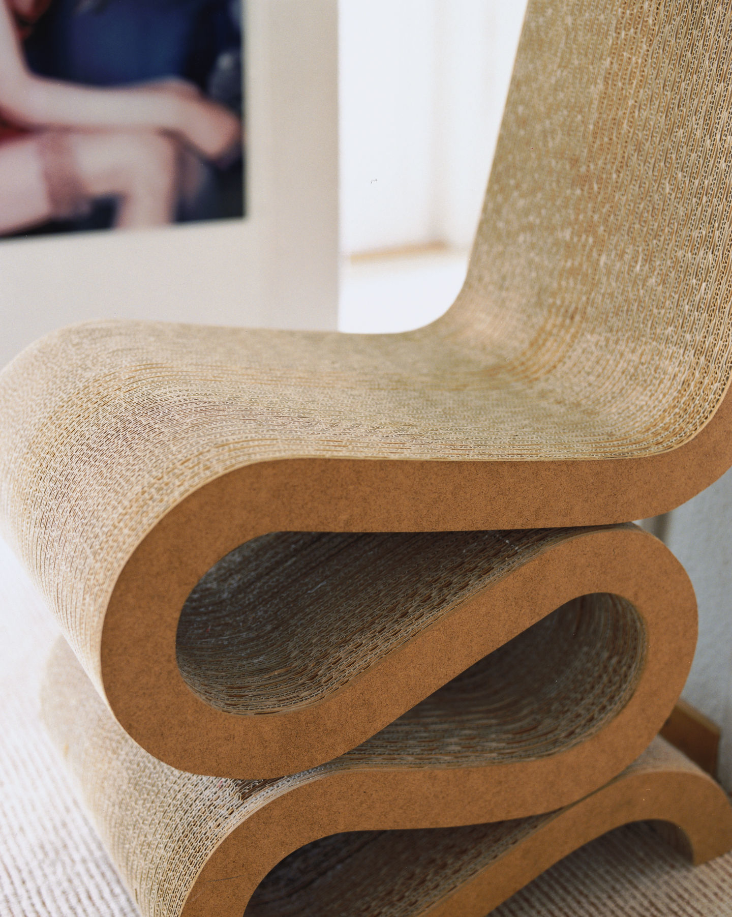 Nahaufnahme des Wiggle Side Chair Stuhls von Vitra, gefertigt aus naturbelassener, gewellter Pappe.