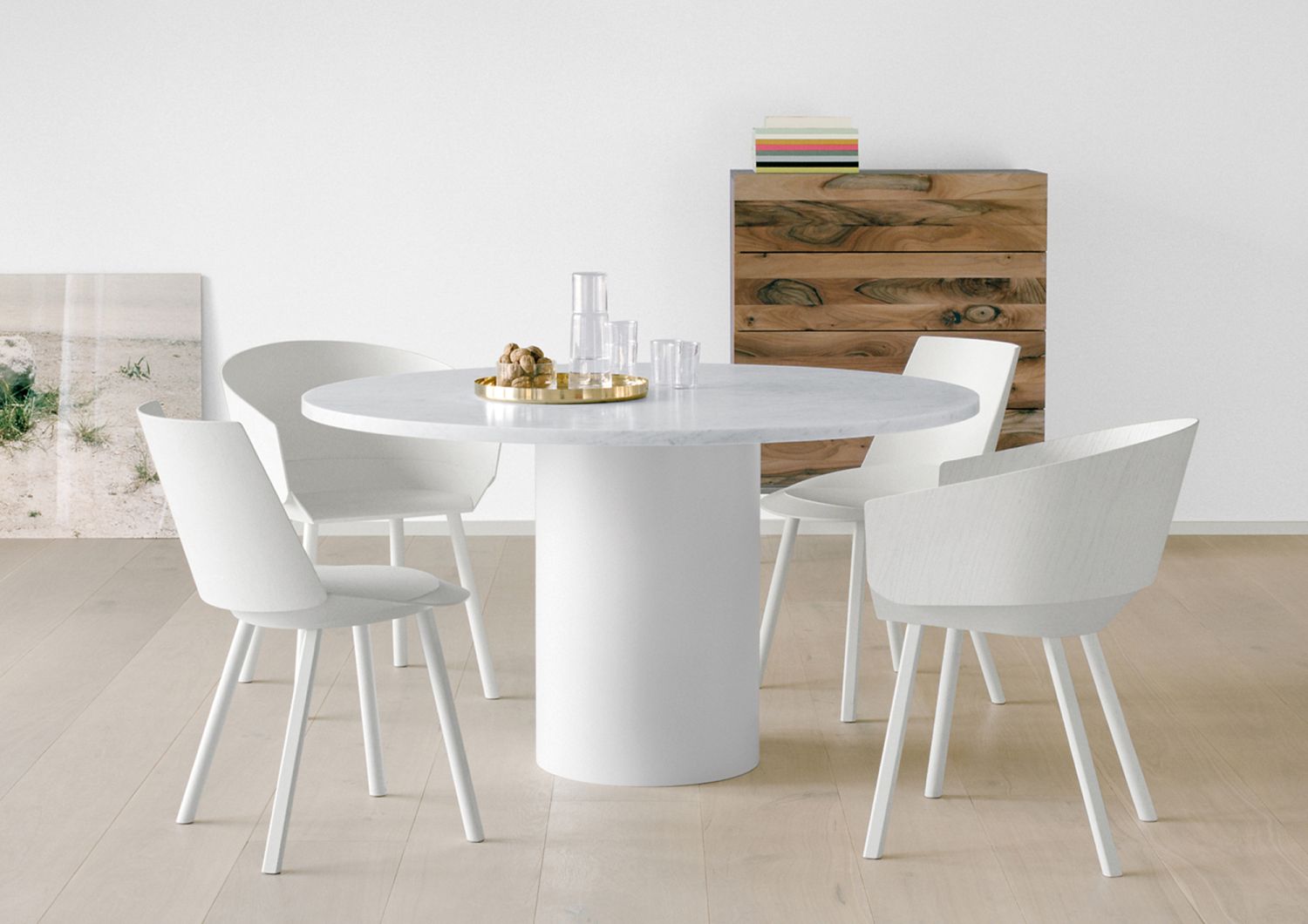 Runder Esstisch Hiroki mit Marmorplatte Bianco Carrara und weißen Stühlen im modernen Esszimmer.