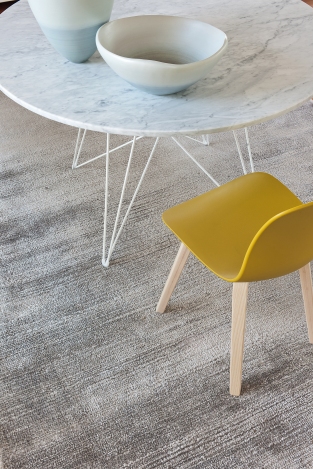 Runder Magis Tavolo XZ3 Tisch mit Marmorplatte und weißem Drahtgestell, kombiniert mit gelbem Stuhl.