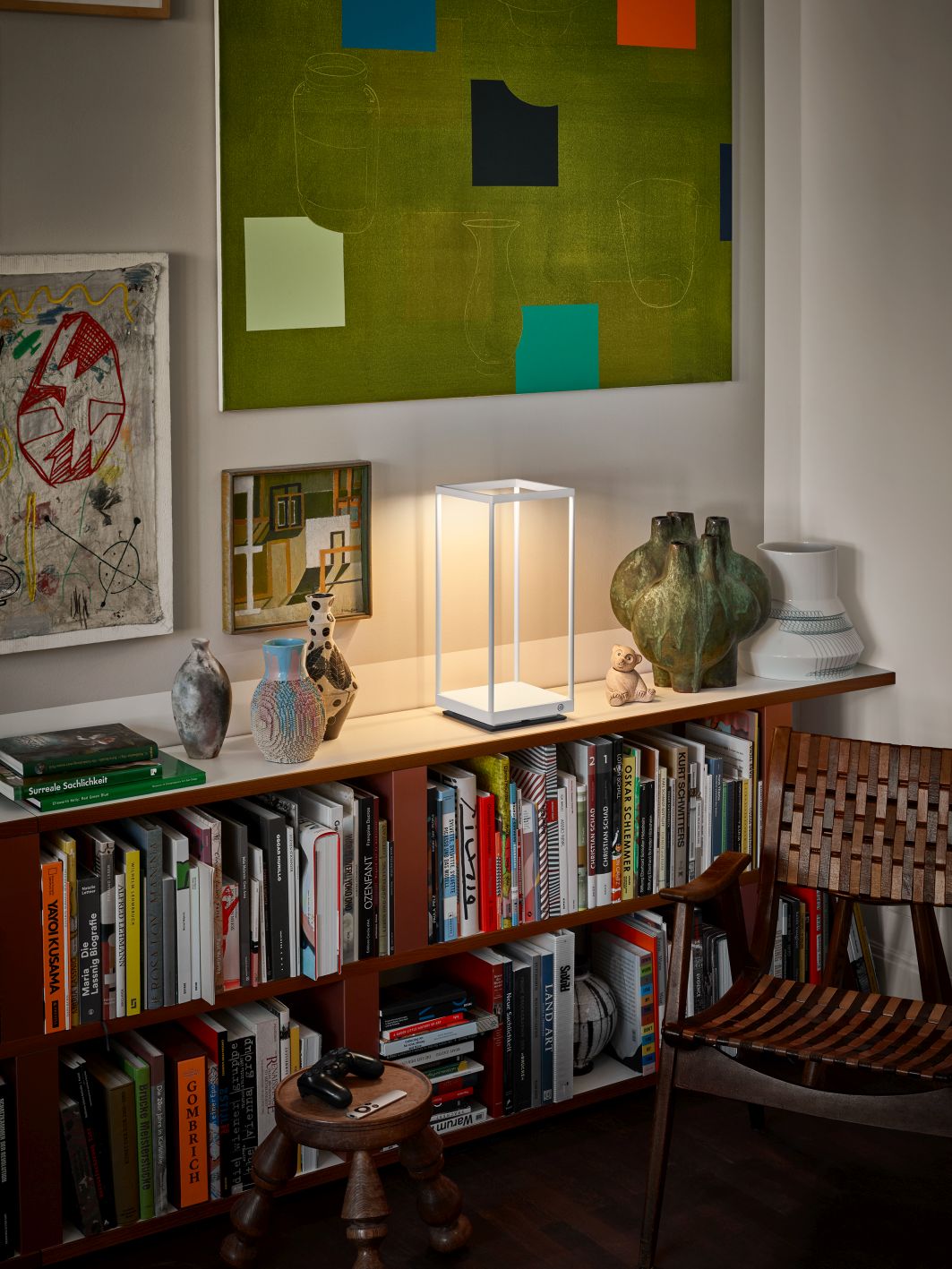 Weiße Reflex² Tischleuchte von Serien Lighting auf Regal mit Büchern und Dekoration. Moderne Lampe.