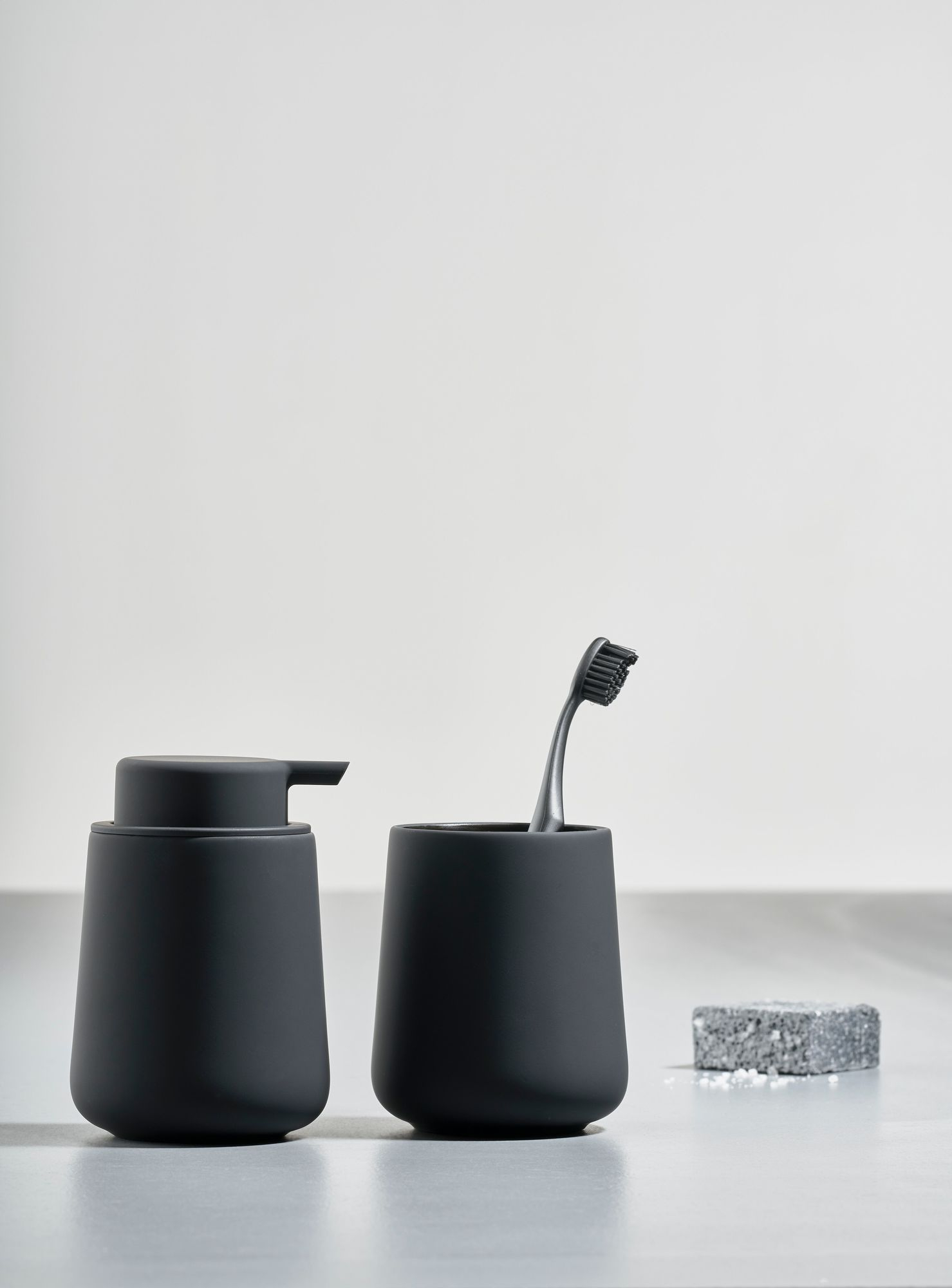 Zone Denmark Bad-Accessoires: Seifenspender, Zahnputzbecher und Seife in Anthrazit für moderne Badezimmergestaltung.