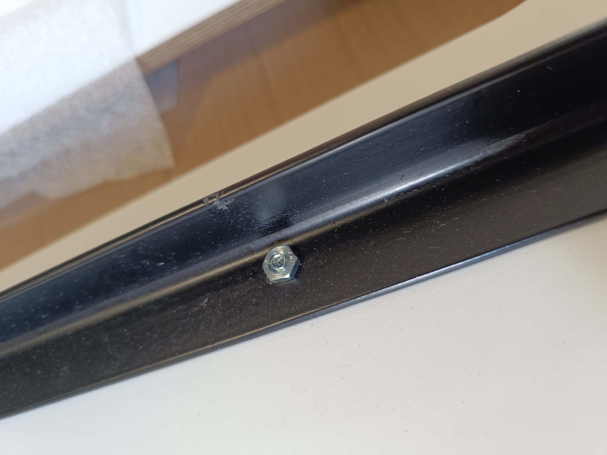 Detailaufnahme: Schraube am Rahmen der weißen Stapelliege von Müller Möbelwerkstätten.