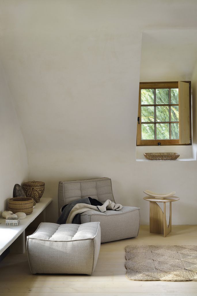 N701 Sofa Polsterhocker von Ethnicraft in hellem Raum mit Fenster und Deko-Elementen.