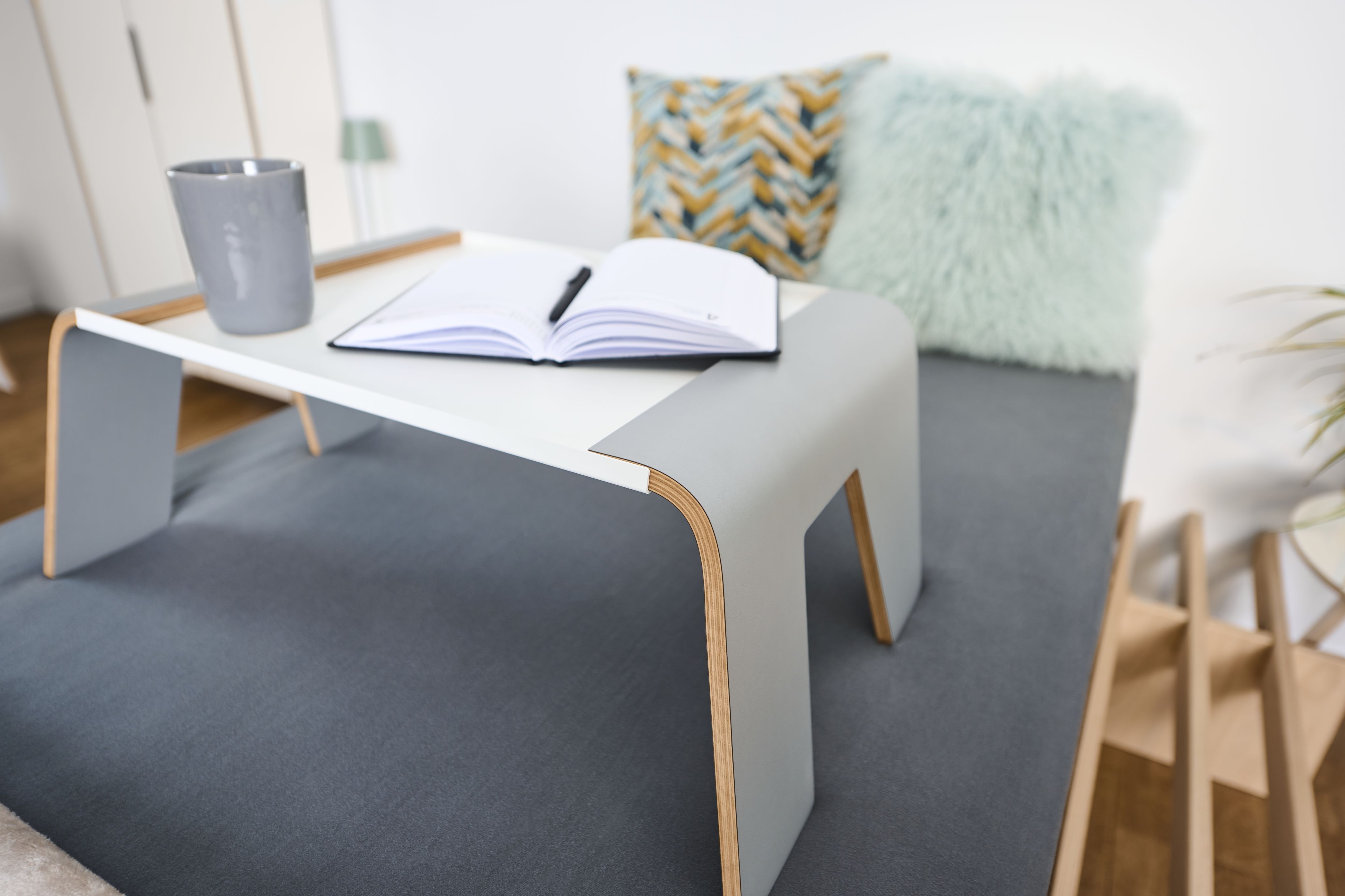 Tojo Notebook-Tablett auf Bett mit Notizbuch, Stift und Tasse. Praktischer Betttisch für Frühstück oder Arbeit.