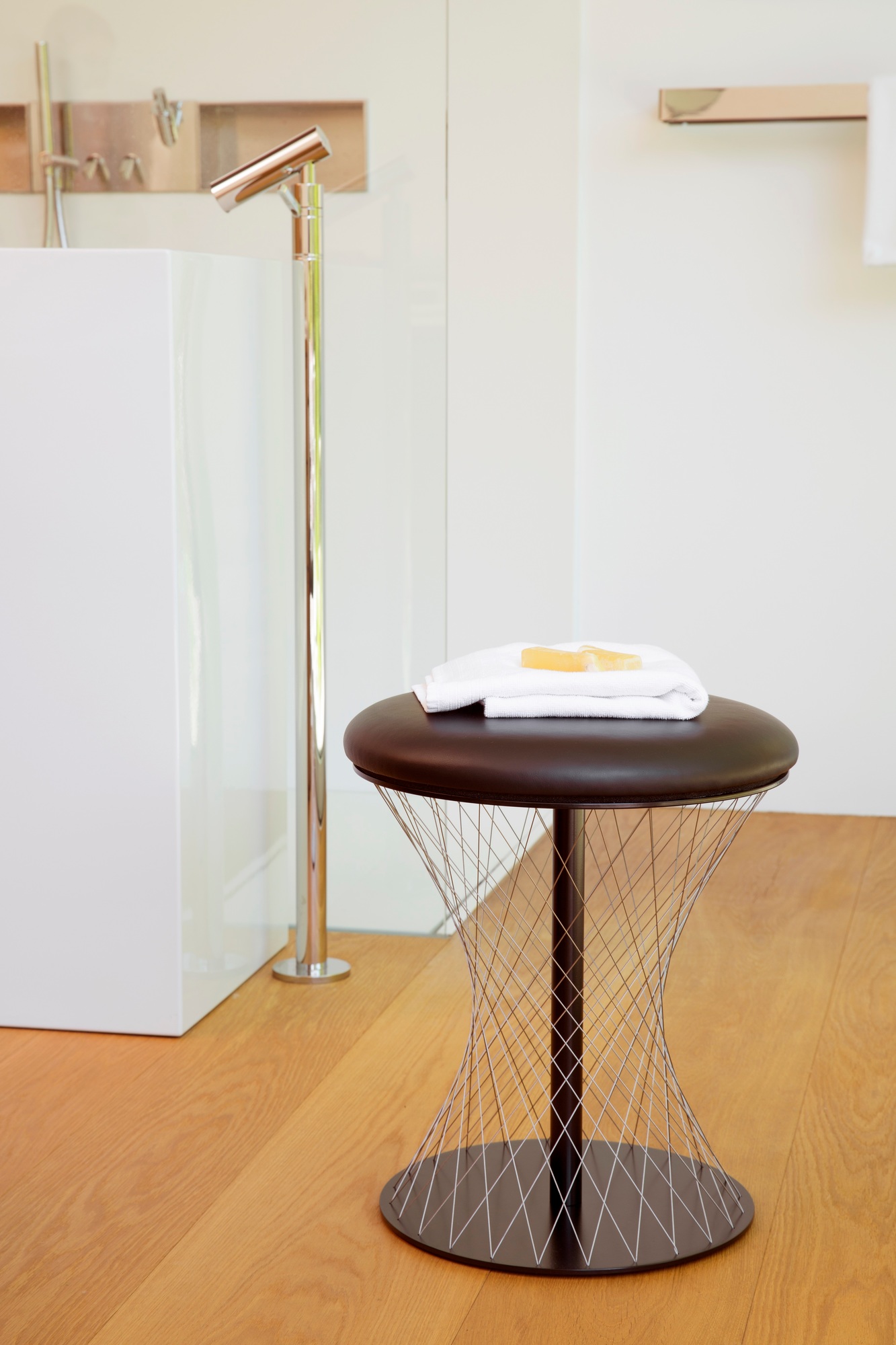 Grauer Hocker mit Handtuch und Seife im Badezimmer. Network Stool ähnliches Design.