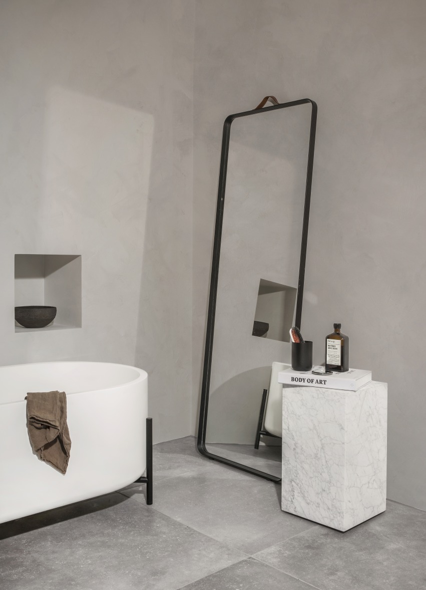 Badezimmer mit freistehender Badewanne und Norm Floor Mirror Wandspiegel von Audo mit schwarzem Rahmen.