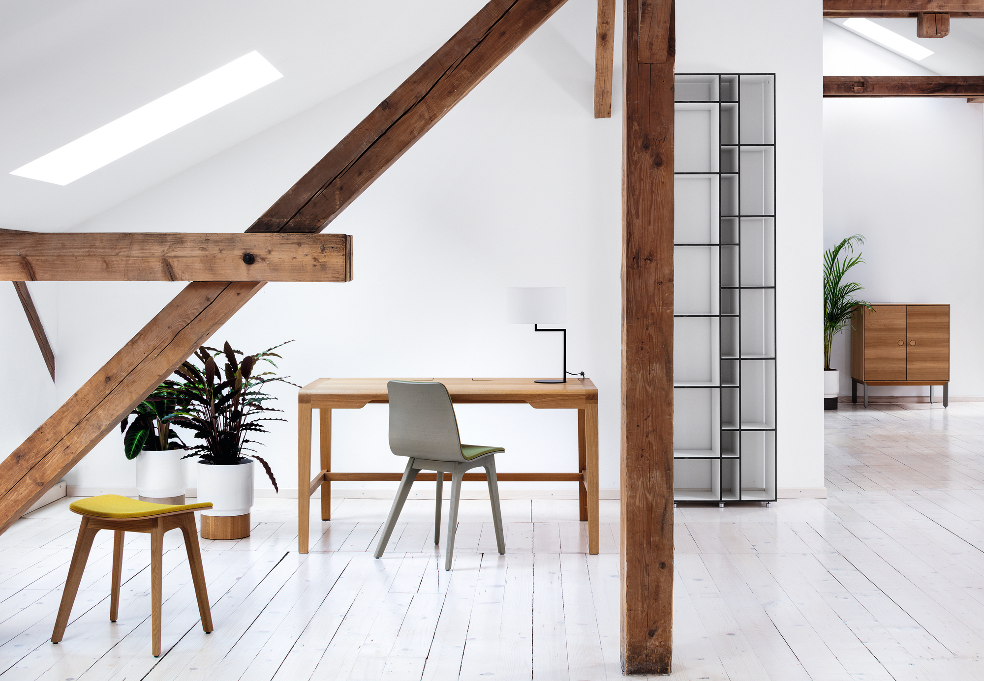 Helle Büroeinrichtung mit Neat Noon Tischleuchte in Weiß, Schreibtisch, Stuhl und Holzdekor.