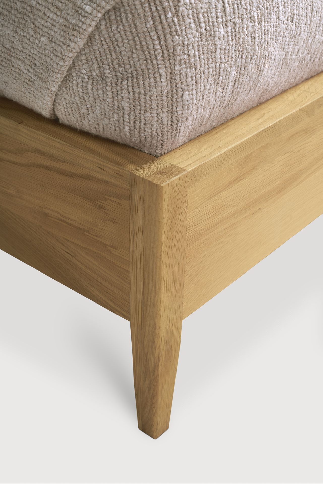 Detailansicht des Ethnicraft Spindle Bettes: Massivholzrahmen und Bein, natürliche Holzmaserung, modernes Schlafzimmermöbel.