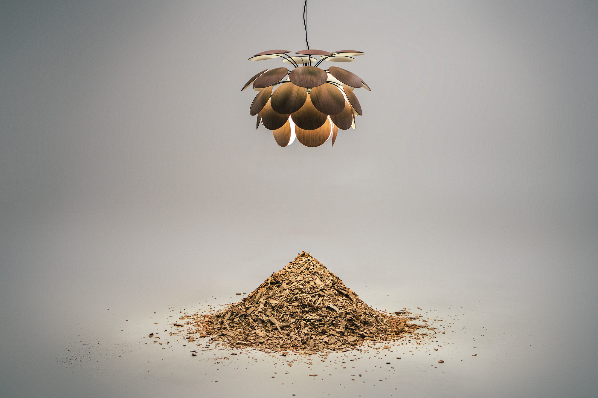 Discocó 68 Pendelleuchte in Schwarz-Gold von Marset: Moderne Hängelampe mit dekorativen Holzscheiben und warmem Licht.