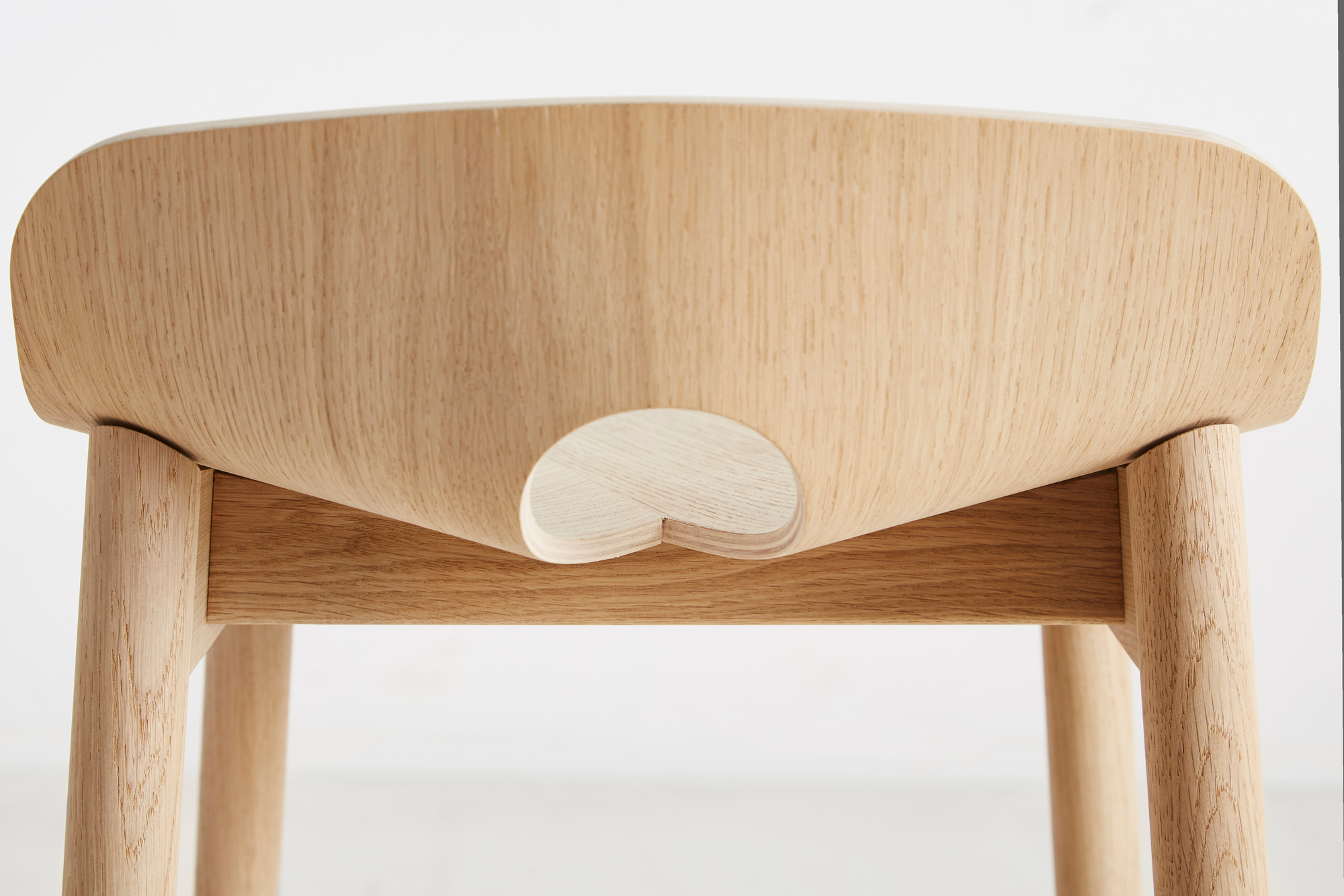 Detailaufnahme: Mono Barhocker aus Eiche, weiß pigmentiert, zeigt die Holzstruktur und Beine.