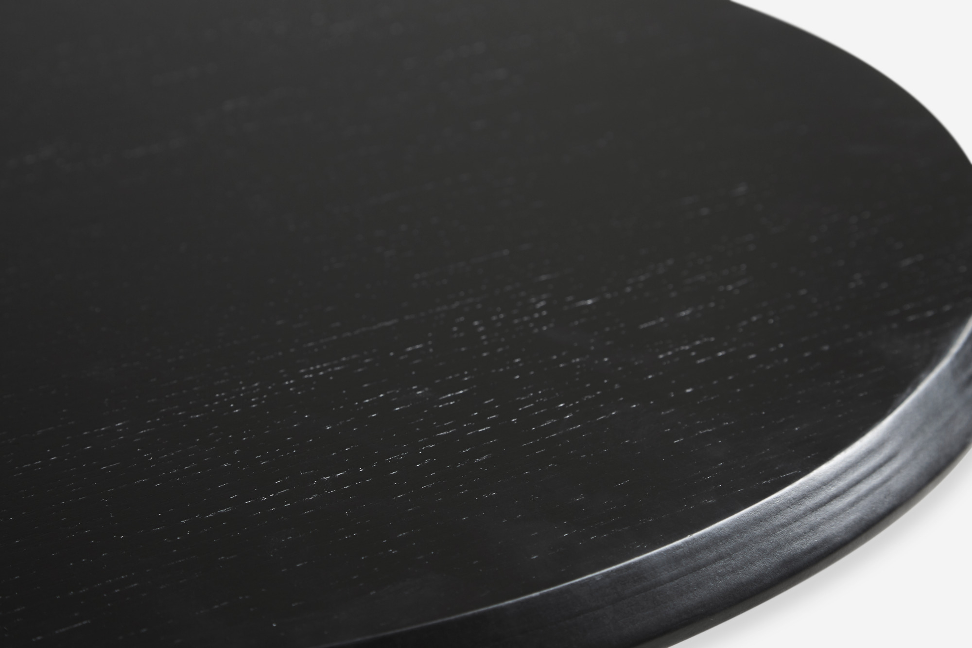 Detailaufnahme der Tischplatte des Soround Couchtischs von Woud in Anthrazit. Runder Beistelltisch.