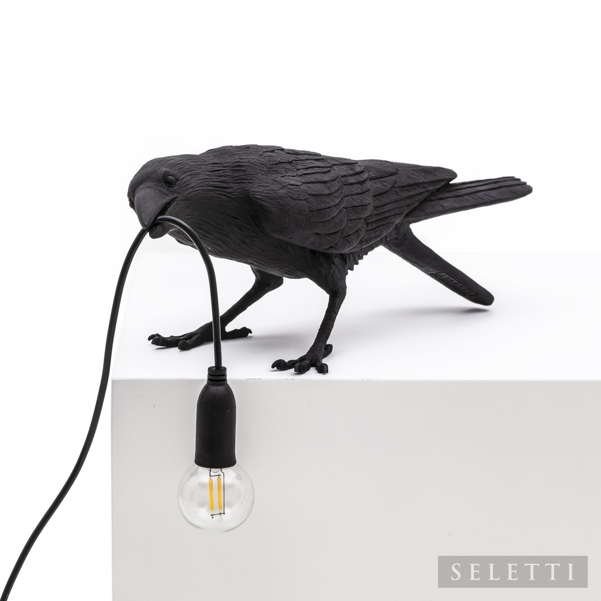 Schwarze Seletti Bird Lamp Playing Leuchte in Form eines Raben mit Glühbirne im Schnabel.