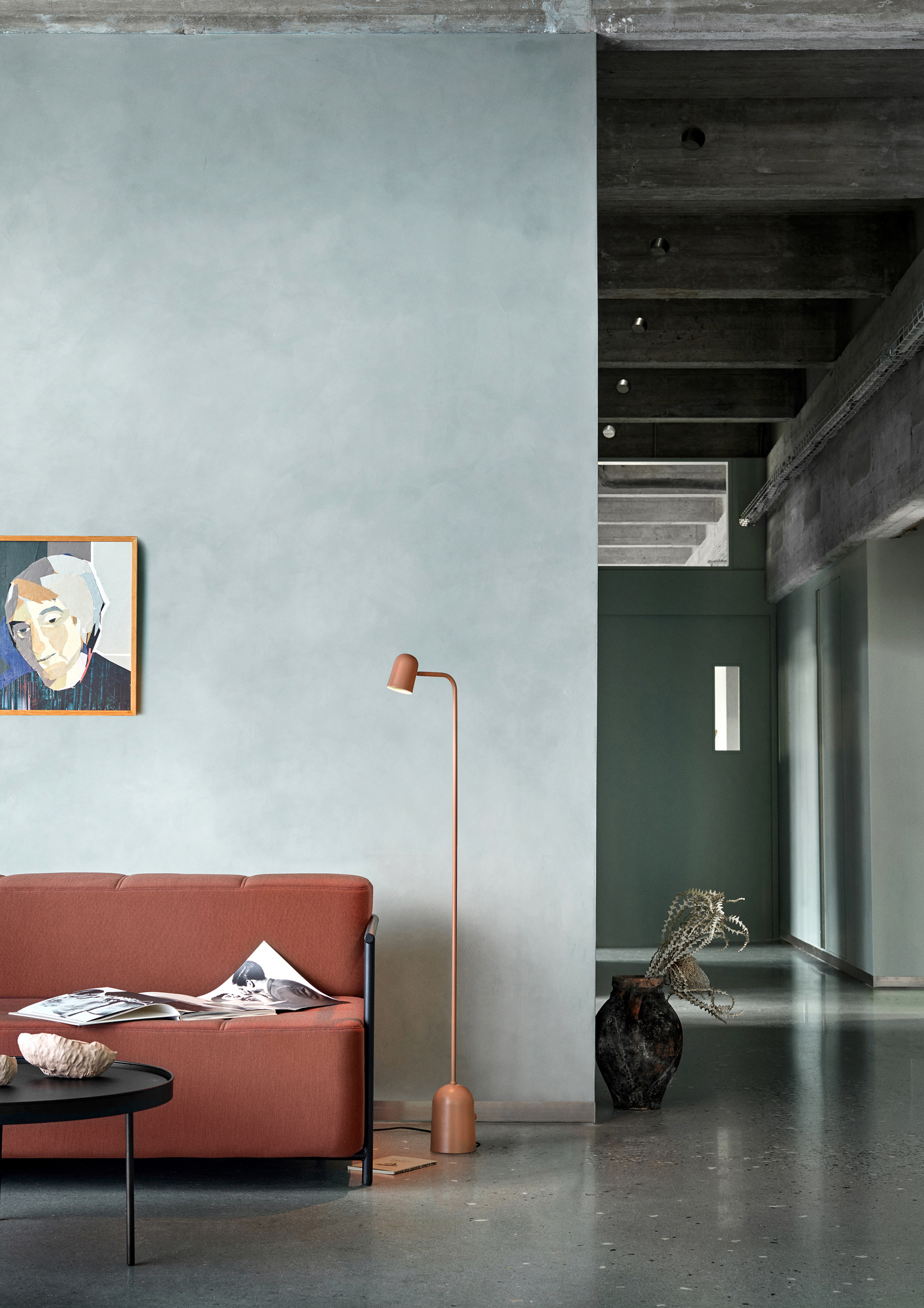 Buddy Floor Stehleuchte von Northern in Kupfer neben Sofa und Beistelltisch in modernem Wohnraum.