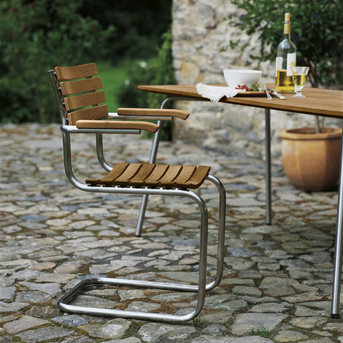 Thonet S 40 Freischwinger Gartenstuhl mit Holzlatten und Stahlrohrgestell im Außenbereich.