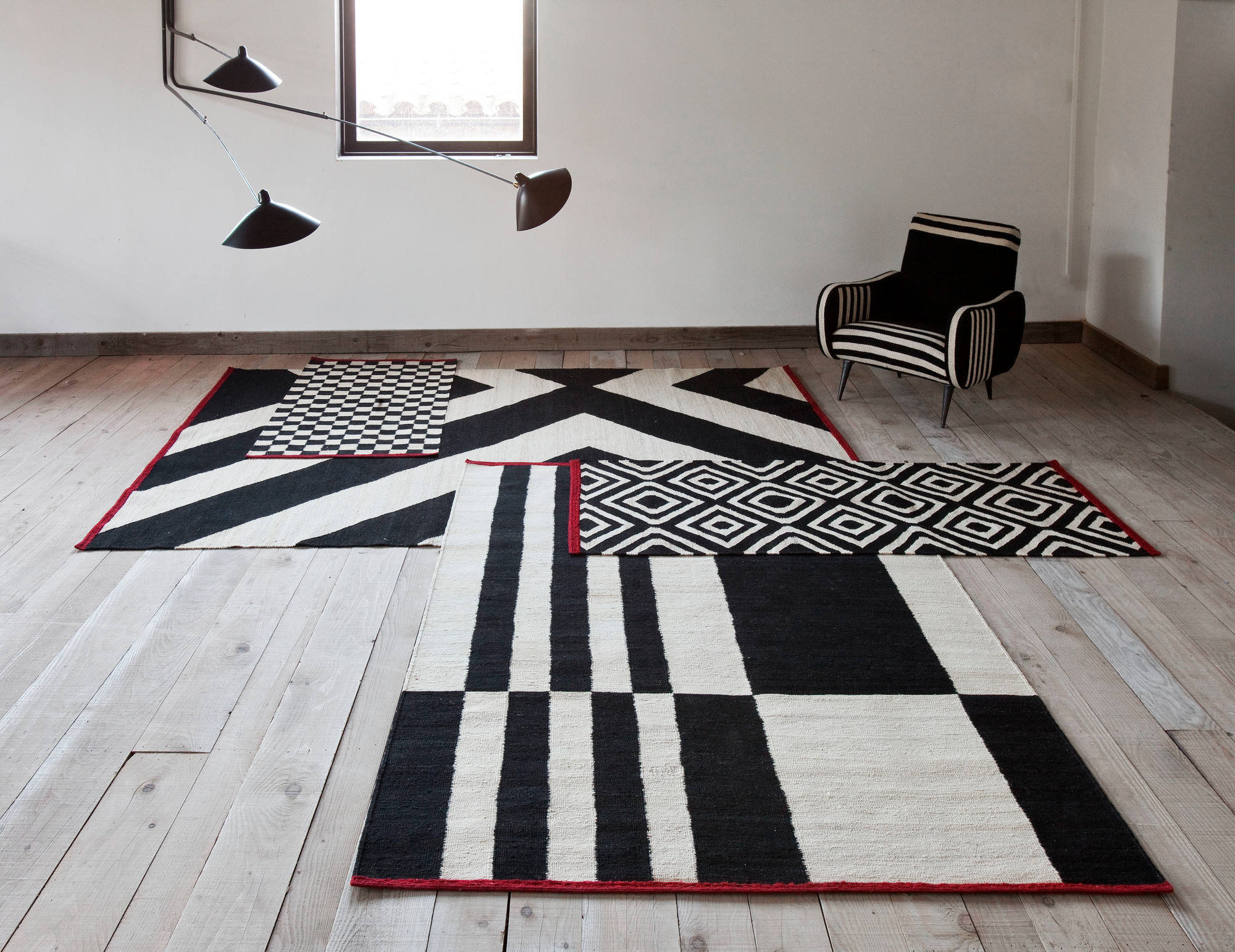 Mélange Stripes Teppich von Nanimarquina, 200x300 cm, mit schwarz-weißen Mustern auf hellem Holzboden.