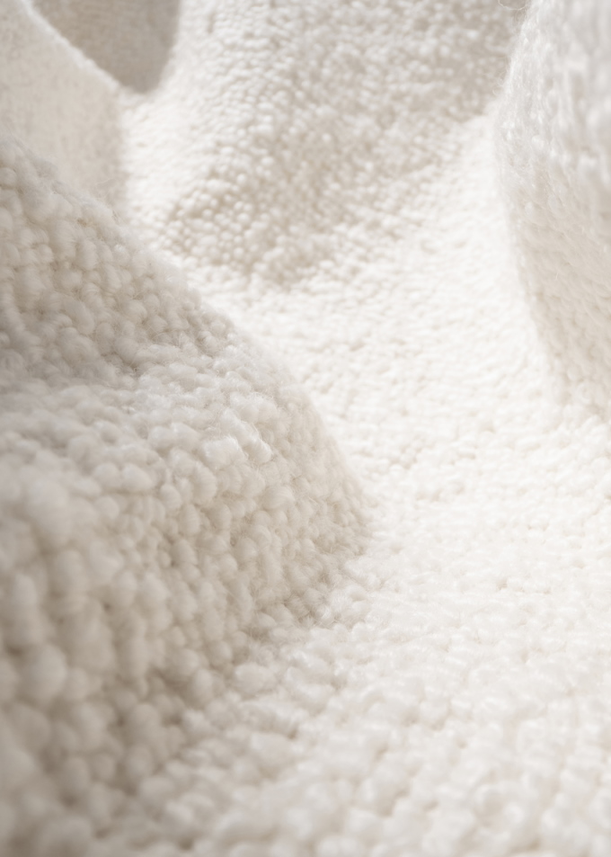 Detailaufnahme des schwarzen Pacha Lounge Chair Sessels von Gubi mit weichem Karakorum-Stoff.