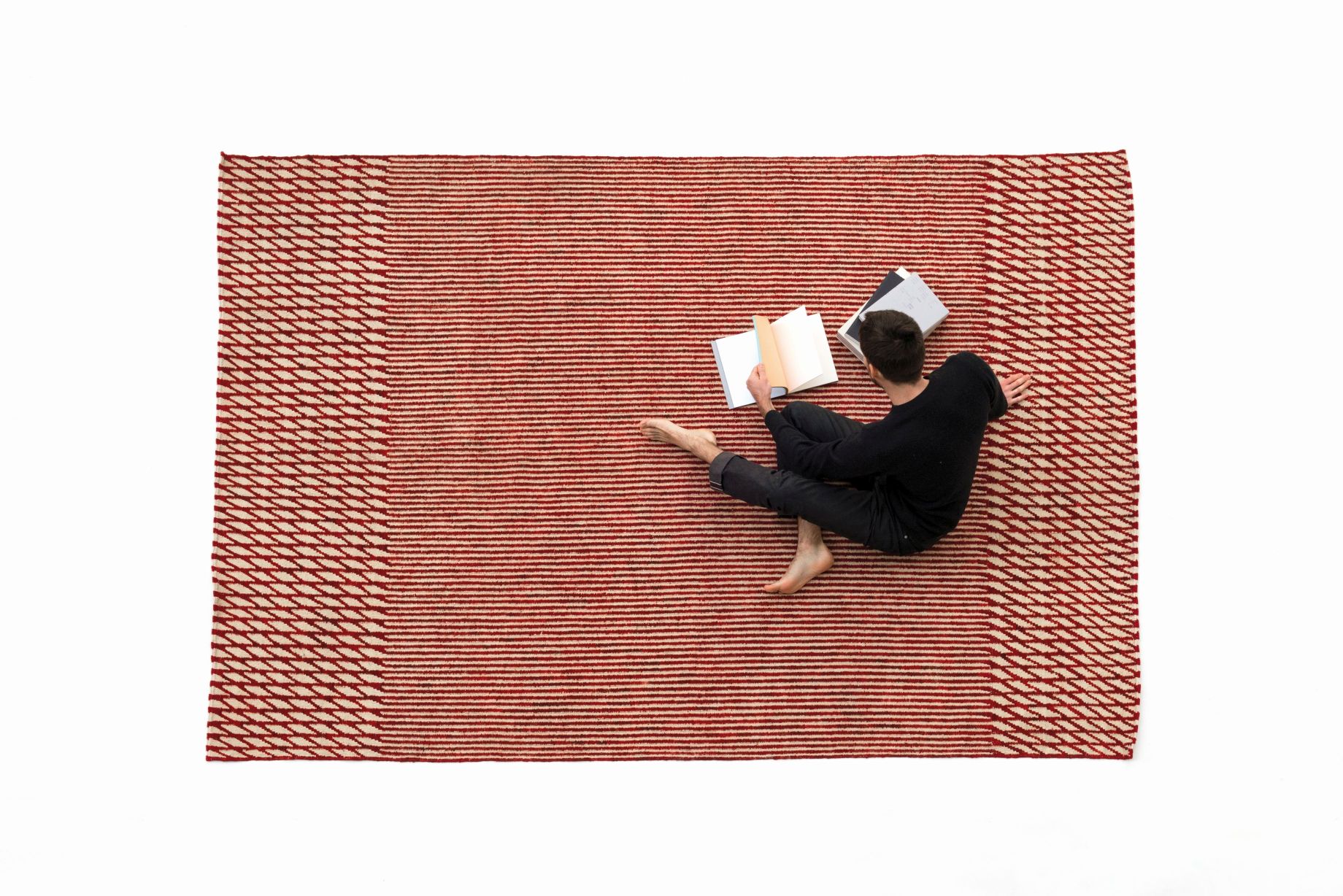 Roter Blur Teppich von Nanimarquina (170x240 cm) mit Person beim Lesen. Design Teppich.