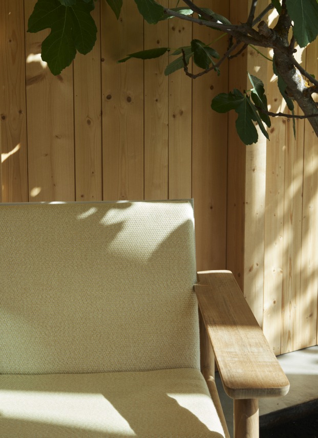 Nahaufnahme des Pelagus Lounge Sessel von Skagerak by Fritz Hansen mit hellem Stoffbezug und Holzarmlehne.