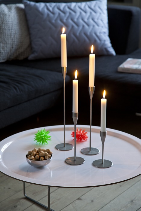 Vier schlanke Mars/Venus Kerzenständer MINI aus Metall mit brennenden Kerzen auf einem Tisch.