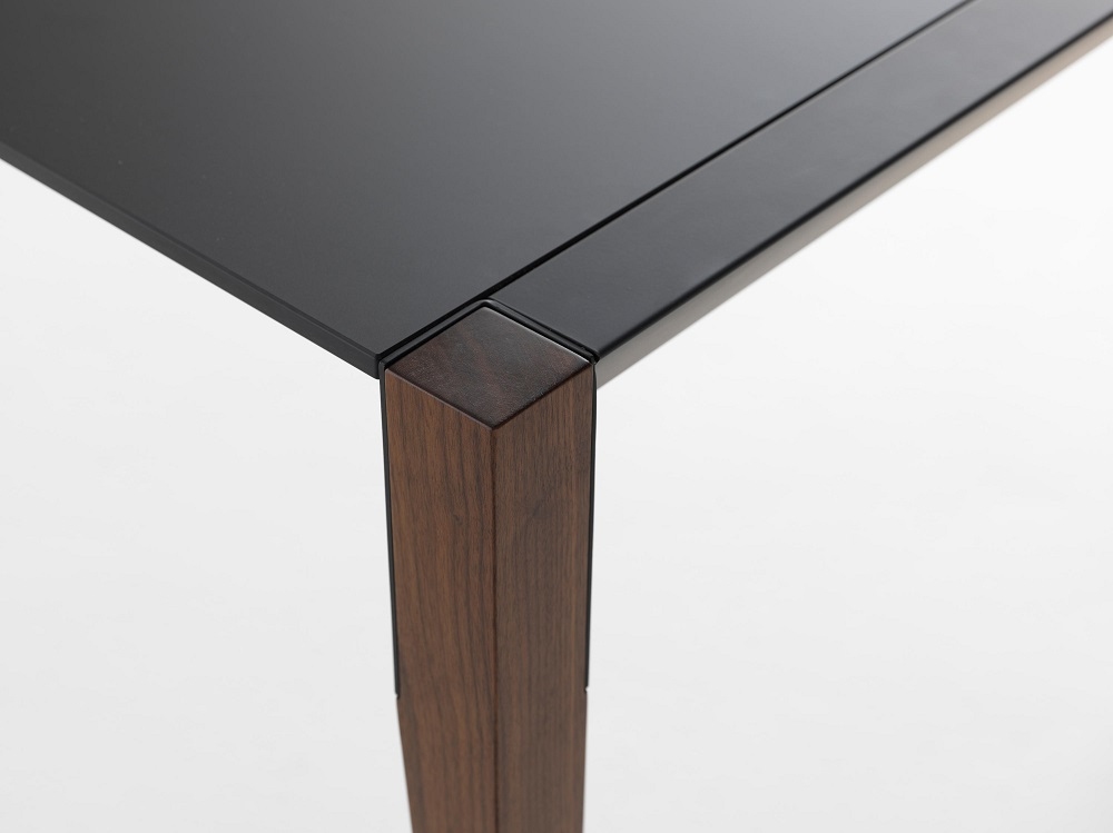 Detailaufnahme vom Tango Estensibile Ausziehtisch Casamania Horm mit schwarzer Tischplatte und Holzbeinen.