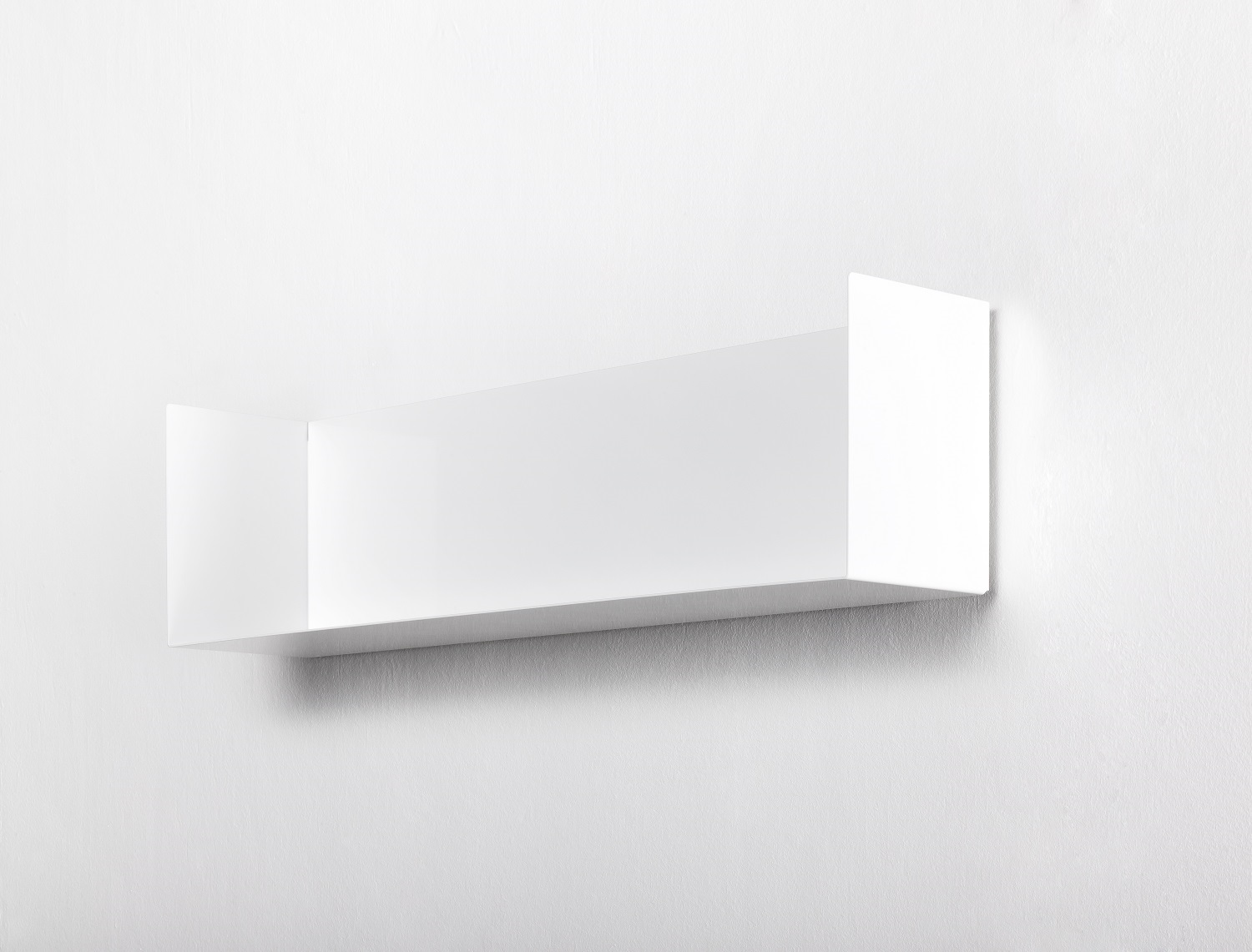 Weißes Taschenbuchregal a Linea1 von Müller Möbelwerkstätten an einer weißen Wand, minimalistisches Design für Bücher und Deko.