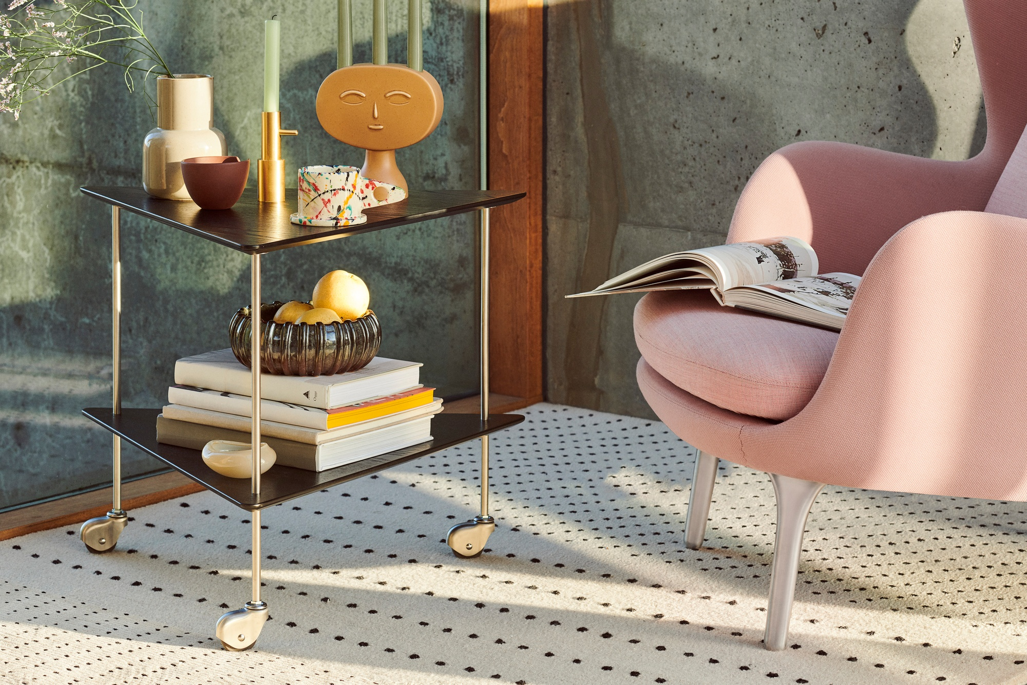 AJ Trolley Beistelltisch von Fritz Hansen, ein Rollwagen mit zwei Ablagen, dekoriert mit Büchern und Objekten.