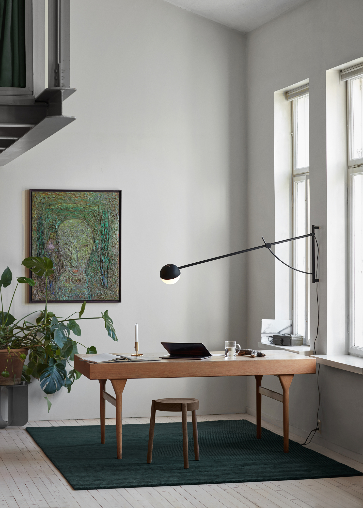 Büro mit Northern Balancer Wall Wandleuchte in Schwarz, die einen Schreibtisch beleuchtet.