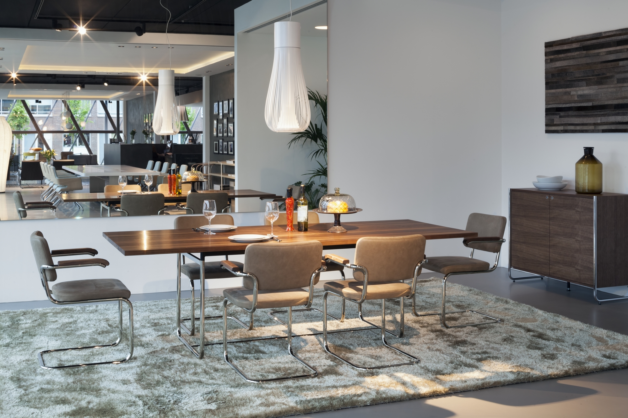 Esszimmer mit Thonet S 1070 Esstisch aus Holz und Freischwinger Stühlen auf einem Teppich.