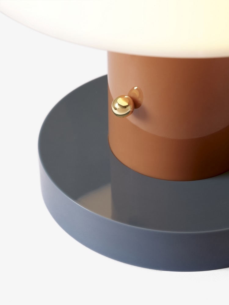 Detailaufnahme der Setago JH27 Akkuleuchte von AndTradition: Tischleuchte in Braun und Grau mit goldenem Knopf.