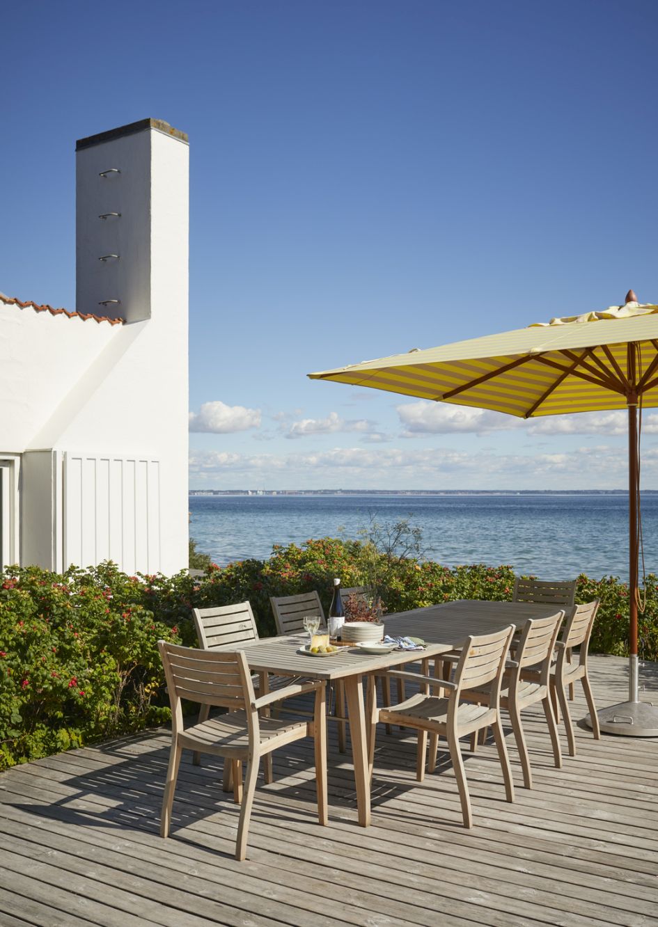 Ballare Tisch von Skagerak: Outdoor Esstisch mit Stühlen und Meerblick. Gartenmöbel aus Holz.