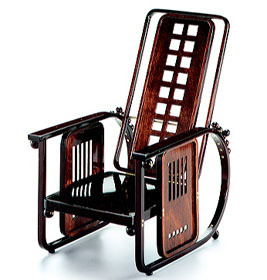 Miniatur-Sitzmaschine [1905] von Vitra: Detailaufnahme des Holzstuhls mit markantem Design und dunkler Holzfarbe. Designmöbel für Sammler.