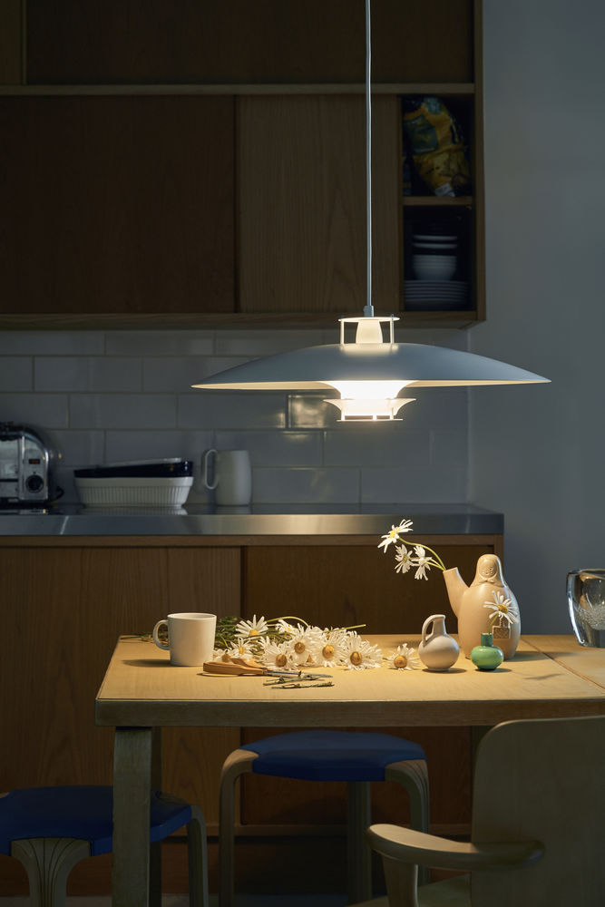 JL341 Pendelleuchte von Artek, weiße Designerlampe über Esstisch mit Blumen und Geschirr.