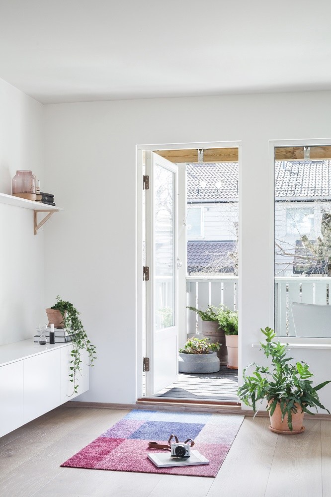 Blick in ein helles Zimmer mit Heymat Fußmatte in Rosa und Blau.