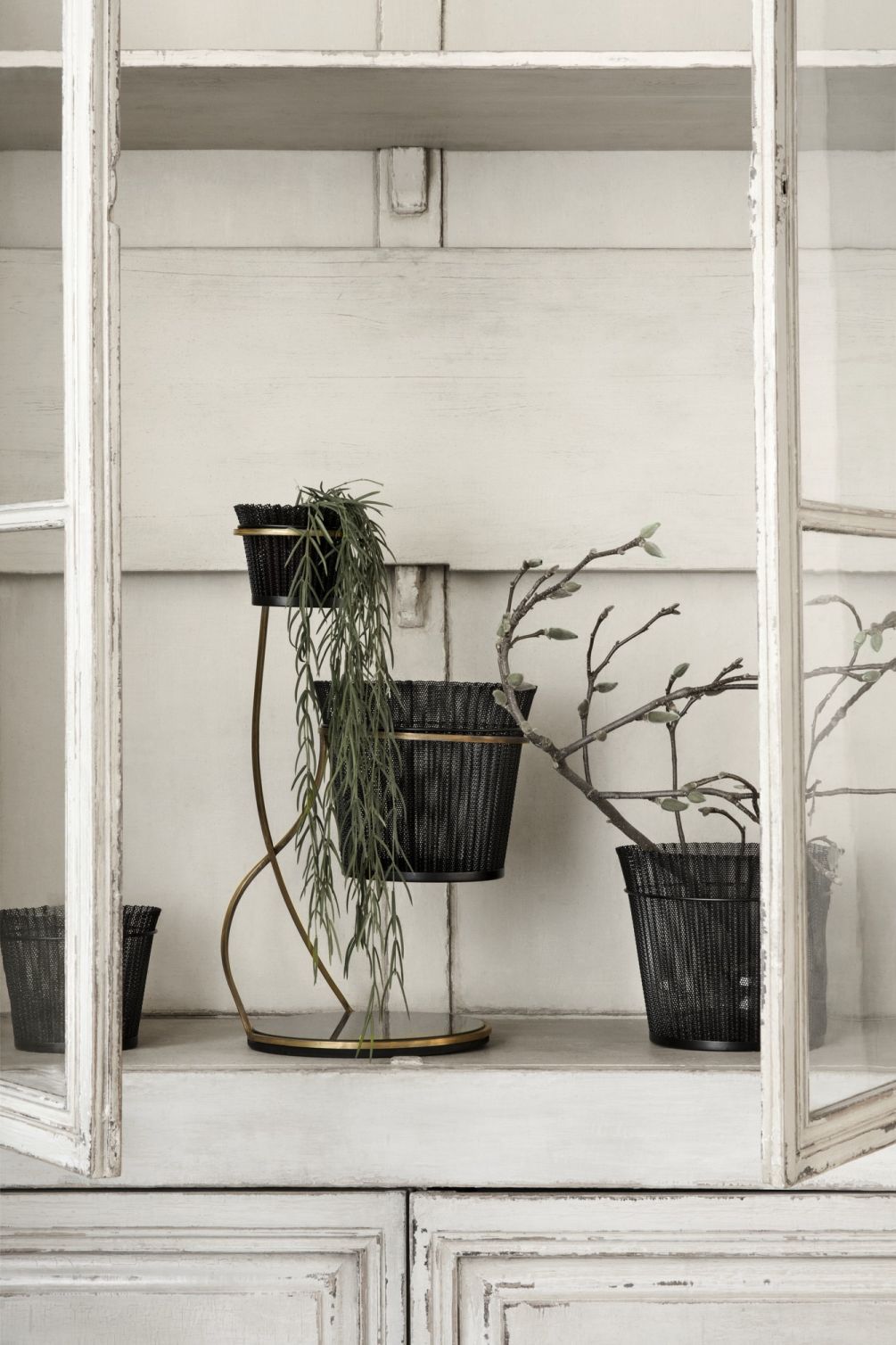 Matégot Blumentopf von Gubi, schwarzer Metall-Blumenständer mit zwei Töpfen und Pflanzen in einem Schrank.